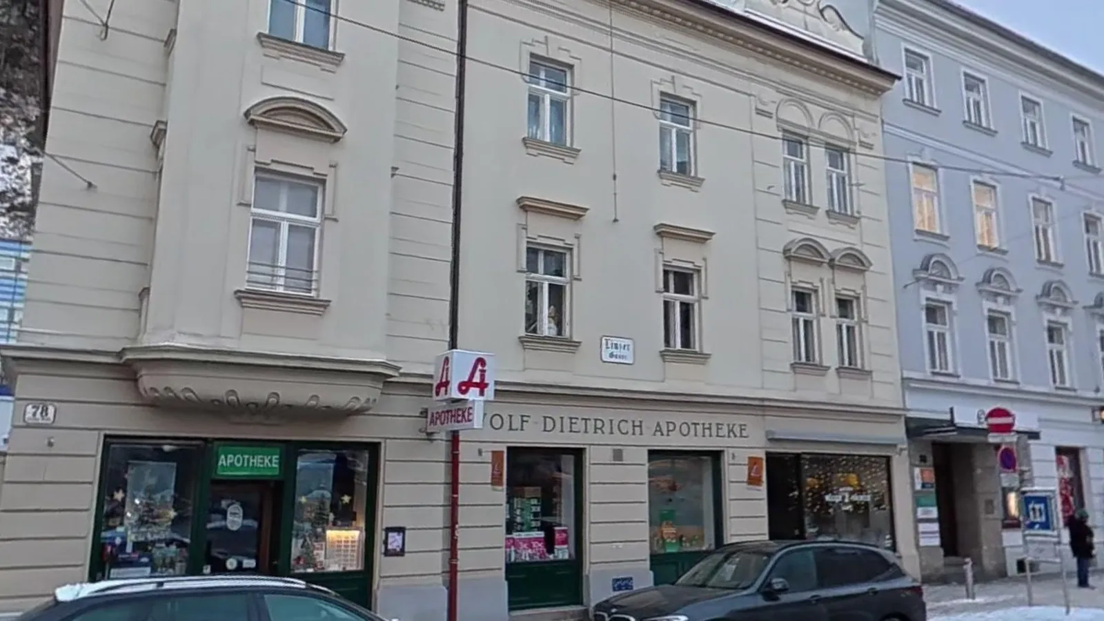 Eckhaus Linzer Gasse 78 in Salzburg mit dem Schriftzug „Wolf-Dietrich-Apotheke“, dem roten Apotheken-A und grün gerahmtem Eingang