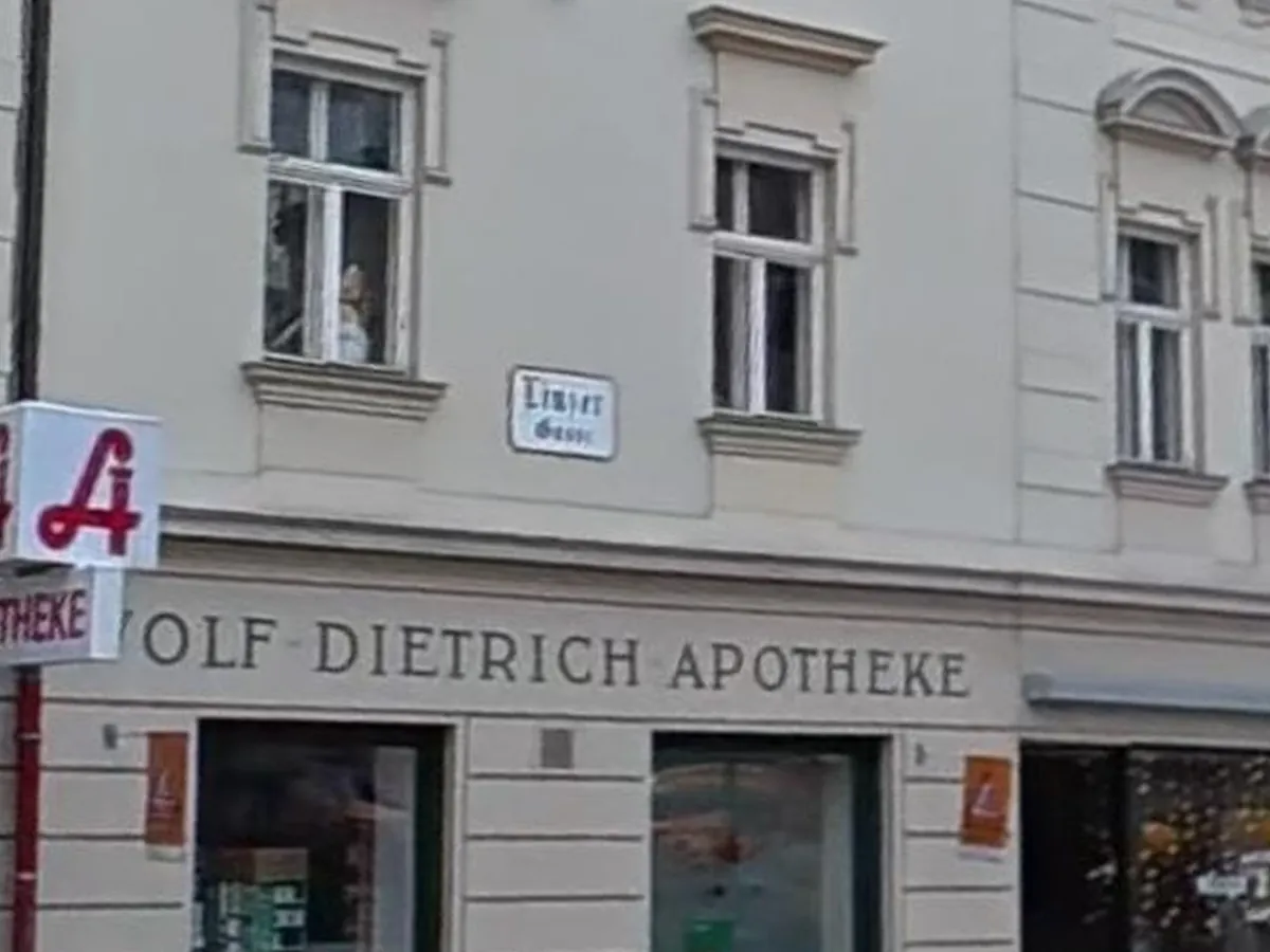 Fassadenschriftzug „Wolf-Dietrich-Apotheke“ über den Schaufenstern, links das Apotheken-A